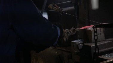 Isıtılmış malzemeleri çekiçle şekillendiren bir zanaatkar..