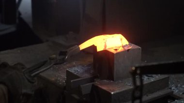 Isıtılmış malzemeleri çekiçle şekillendiren bir zanaatkar..