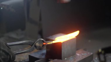 Isıtılmış malzemeleri çekiçle şekillendiren bir zanaatkar..