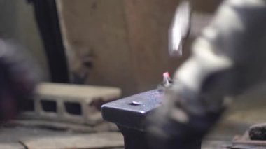 Isıtılmış malzemeleri çekiçle şekillendiren bir zanaatkar..