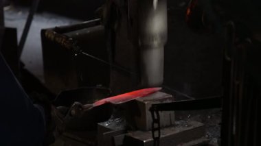 Isıtılmış malzemeleri çekiçle şekillendiren bir zanaatkar..