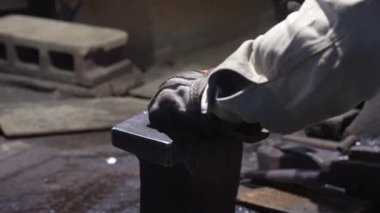 Isıtılmış malzemeleri çekiçle şekillendiren bir zanaatkar..