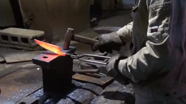 Isıtılmış malzemeleri çekiçle şekillendiren bir zanaatkar..