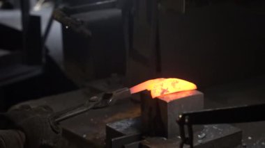 Isıtılmış malzemeleri çekiçle şekillendiren bir zanaatkar..