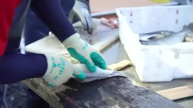 Bir adam balığı fileto yapıyor.