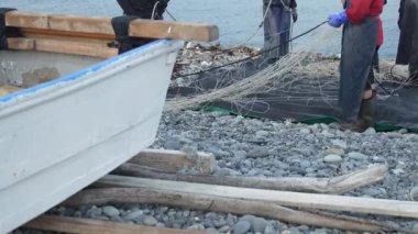 Balıkçılar ağlarını temizliyor