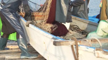 Balıkçılar ağlarını temizliyor