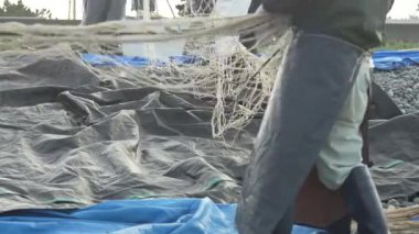 Balıkçılar ağlarını temizliyor