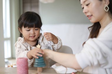 Ebeveynler ve çocuklar küçük bir Noel ağacı süslüyorlar.