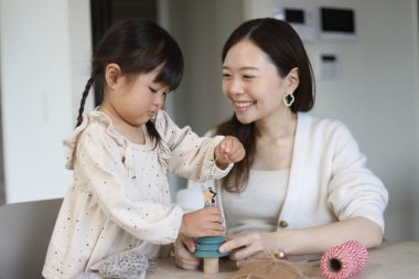 Ebeveynler ve çocuklar küçük bir Noel ağacı süslüyorlar.