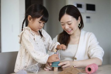 Ebeveynler ve çocuklar küçük bir Noel ağacı süslüyorlar.