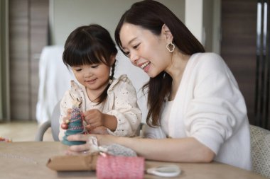 Ebeveynler ve çocuklar küçük bir Noel ağacı süslüyorlar.