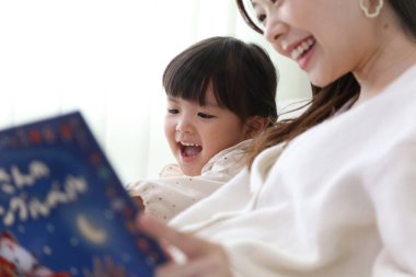 Ebeveynler ve çocuklar resim kitapları okuyor.