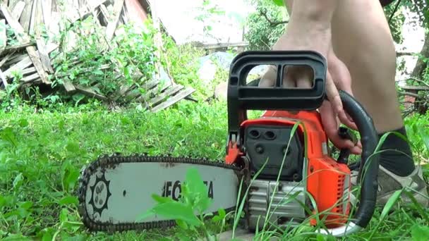 Man starts chainsaw on the outdoor — Stock Video