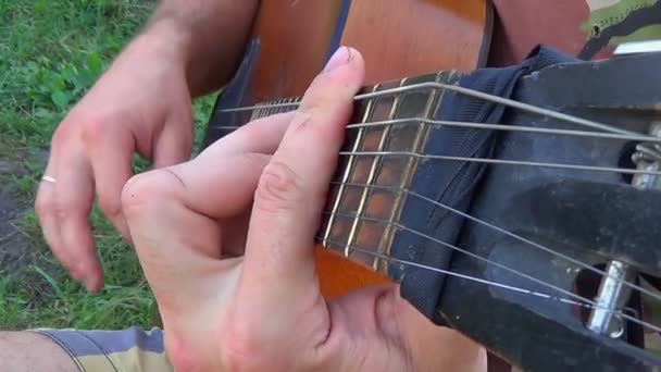 Man elegante Plucks de strijkers, gitaarspelen op natuurlijke achtergrond. — Stockvideo