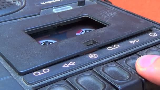 Close-up naar een cassettedeck cassette wanneer een vinger start en stopt met spelen. — Stockvideo