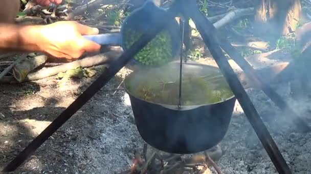 Acampamento turistas de comida. Comida na panela por cima do fogo. Cozido em uma fogueira — Vídeo de Stock