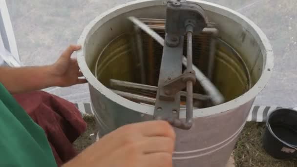 Handmatig centrifugeapparaat dat de honing uit cellen draaien.Honingzuiger draait met frames met honingraten, honing pompen. Honing halen uit honingraat. — Stockvideo