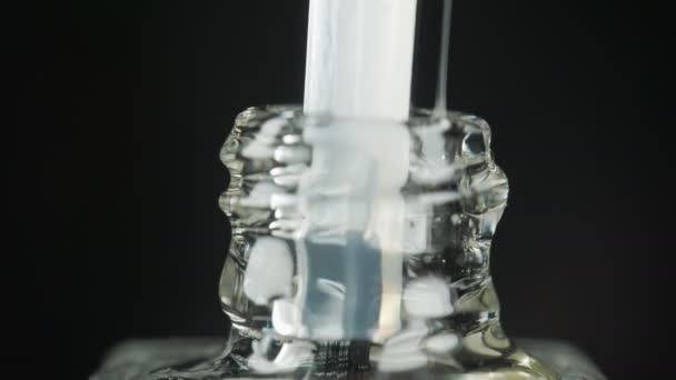 Transparante gel nagellak met een open fles en een druppel druppelend in een pot met een borstel in de schoonheidssalon. Zwarte achtergrond. Close-up. — Stockvideo