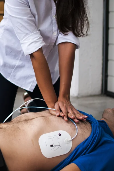 Menina fazendo ressuscitação cardiopulmonar para um homem inconsciente — Fotografia de Stock