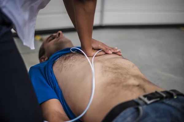 Rescuer making cardiopulmonary resuscitation to an unconscious man — Stock Photo, Image