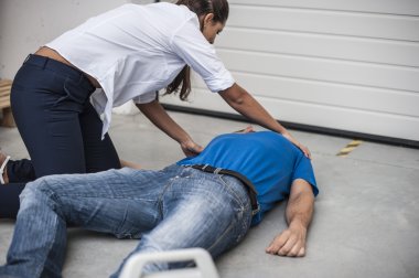 girl assisting an unconscious man with defibrillator clipart