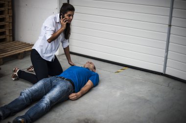 girl calling emergency service for an unconscious man clipart