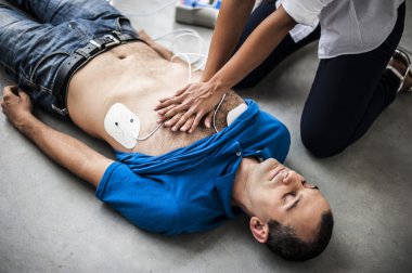 Defibrilatör ve Cpr bilinçsiz bir adamla yardımcı kız