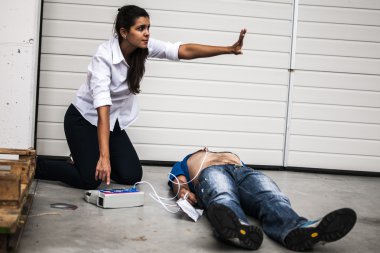 Defibrilatör ve Cpr bilinçsiz bir adamla yardımcı kız