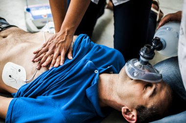 girl assisting an unconscious guy with CPR clipart