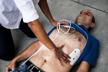 defibrilatör yastıkları uygulamak için bilinçsiz bir adam kız