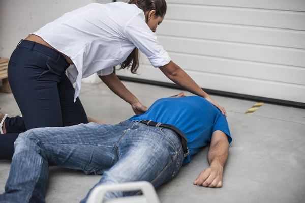 Menina assistindo um homem inconsciente com desfibrilador — Fotografia de Stock