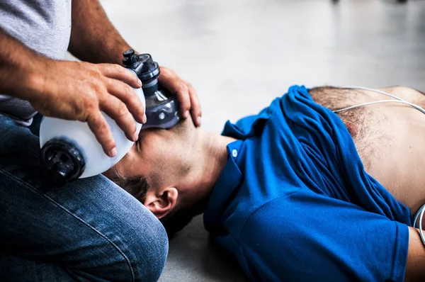 Kerl unterstützt einen bewusstlosen Kerl mit cpr — Stockfoto