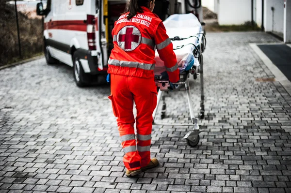 Operadores voluntários de emergência com dispositivos médicos, maca e ambulância — Fotografia de Stock