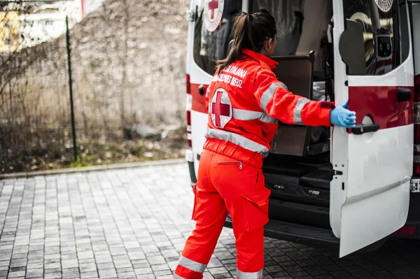 Emergency volunteer operators with medical devices, stretcher and ambulance — Stock Photo, Image