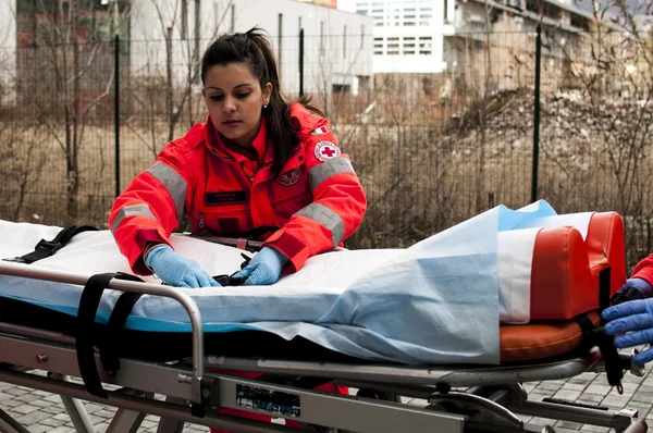 Operadores voluntarios de emergencia con dispositivos médicos, camilla y ambulancia — Foto de Stock