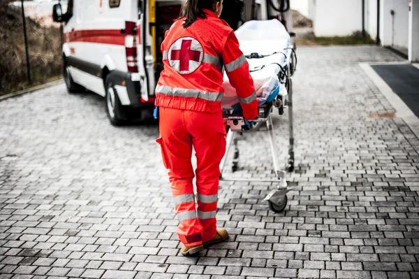 Operador voluntario de emergencia con camilla y ambulancia —  Fotos de Stock