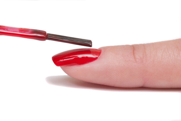 Professional manicurist makes the new red gel polish manicure