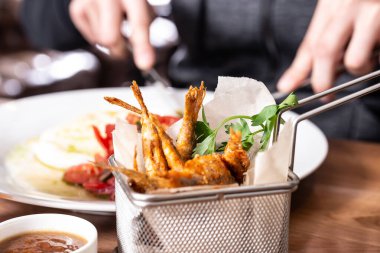 Ahşap bir masada kızartılmış kırmızı kefal balığı sepeti. Alan derinliği