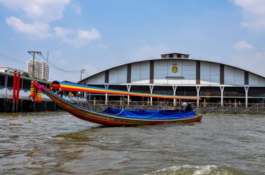 Chao Phraya River panorama in Bangkok, Thailand. Traditional boats and temples against a city skyline. Asian tourism and water transport.