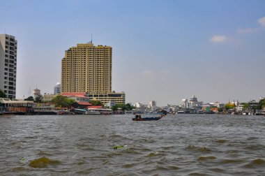 Chao Phraya River panorama in Bangkok, Thailand. Traditional boats and temples against a city skyline. Asian tourism and water transport.