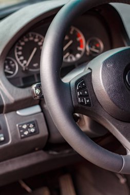 Modern Araç İçi: detayların yakın çekimi, direksiyon, gösterge paneli, kontrol düğmeleri, deri kabin.