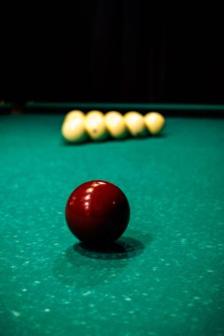 Bilardo masasında, karanlık bir odada hafif lambaların altında duran toplar, yalnızlık, odaklanma ve sessiz oyun ortamı yaratıyor.