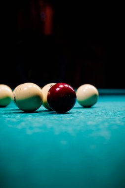 Bilardo masasında, karanlık bir odada hafif lambaların altında duran toplar, yalnızlık, odaklanma ve sessiz oyun ortamı yaratıyor.