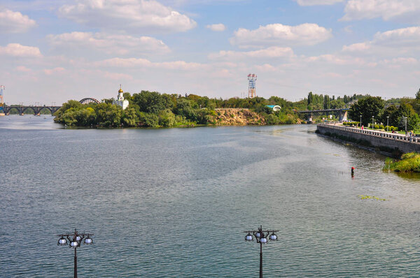 Panoramic View of Dnipro River in Dnipro City, Ukraine: Cityscape with Central Bridge and Modern Skyline Architecture on a Sunny Day