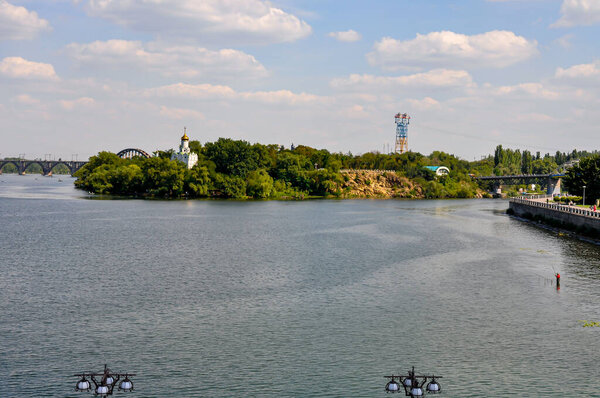 Panoramic View of Dnipro River in Dnipro City, Ukraine: Cityscape with Central Bridge and Modern Skyline Architecture on a Sunny Day