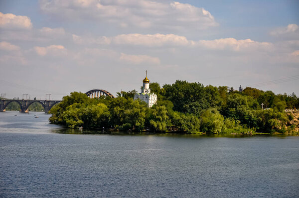 Panoramic View of Dnipro River in Dnipro City, Ukraine: Cityscape with Central Bridge and Modern Skyline Architecture on a Sunny Day