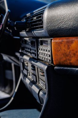 Arka planda Kharkiv Şehir Merkezi Mimarisi ile klasik bir arabanın içinde Wood Trim ve Deri koltuklar, Vintage Car Dashboard ve direksiyon