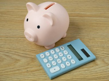 Para veya iş konsepti tasarrufu için domuzcuk bankası ve mavi hesap makinesi