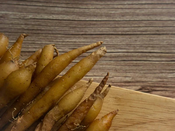 Ahşap masadaki parmak kökü yiyecek ve tıbbi konsept için görüntüyü kapat